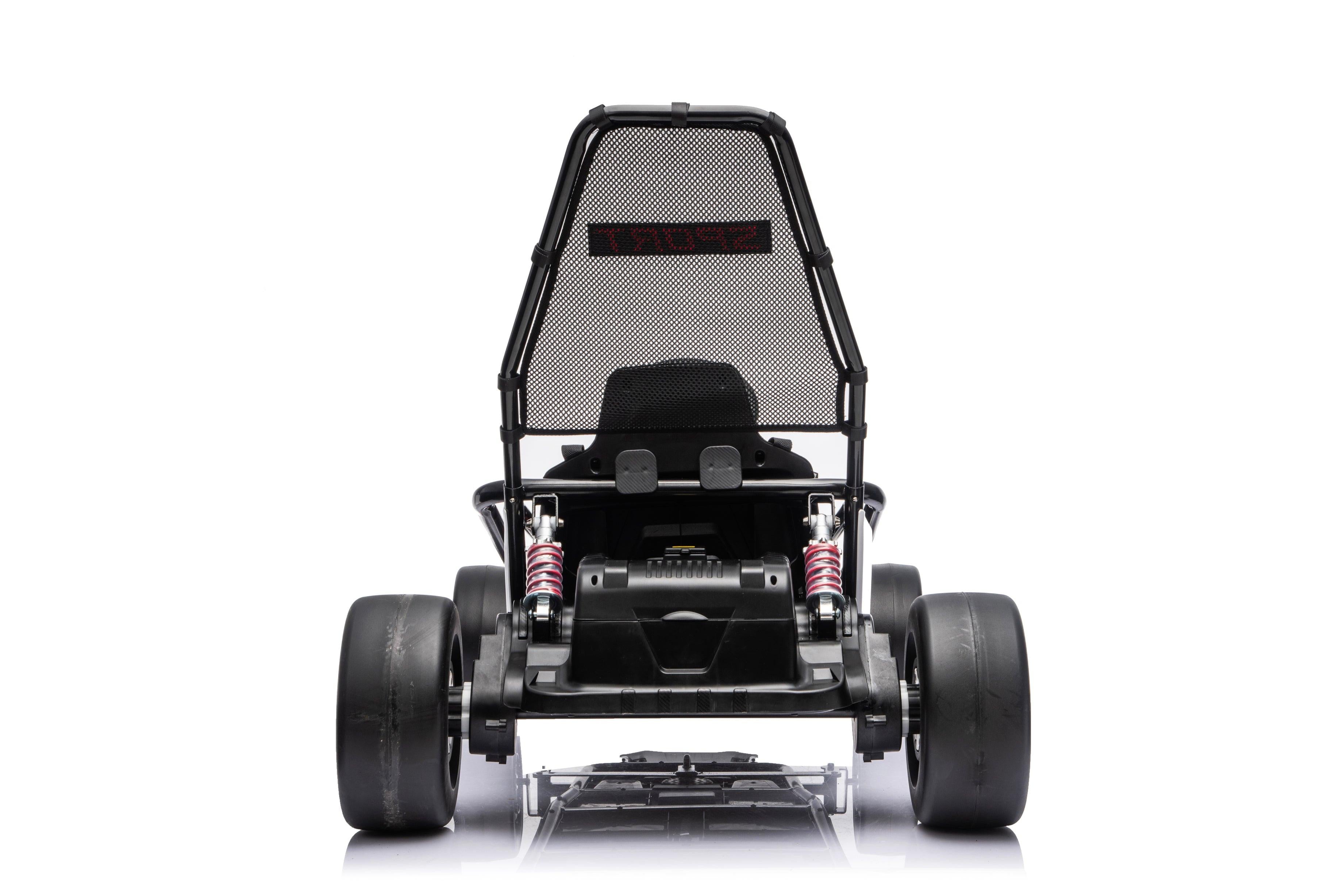 Black Outlaw Edition kids electric go-kart with child riding outdoors on driveway