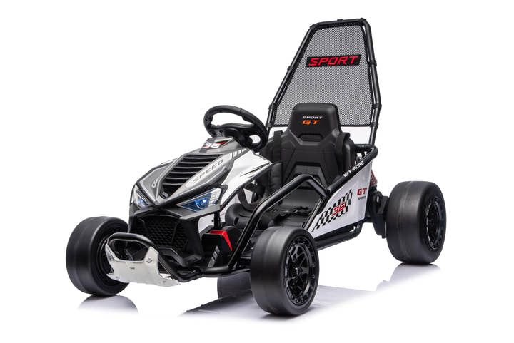 Black Outlaw Edition 24V kids electric go-kart with child riding in a modern showroom