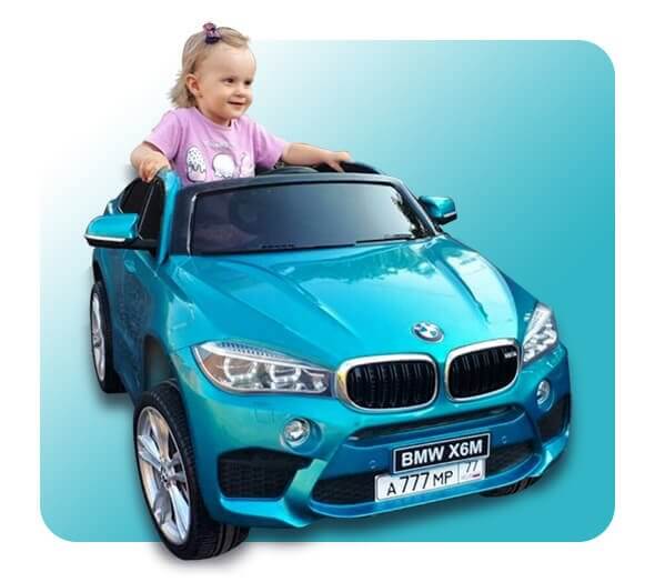 Smiling young girl enjoying a ride in a vibrant teal BMW X6M ride-on car for kids, embodying the fun and freedom of KidsVIP's electric cars for kids, perfect for inspiring imaginative play and adventure in a safe, child-friendly vehicle